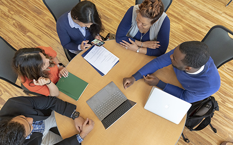 "Gies College of Business students around a table "